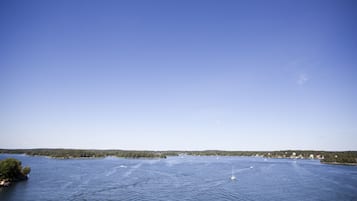 Un extenso cuerpo de agua bajo un cielo despejado, rodeado de tierra con árboles y edificios.