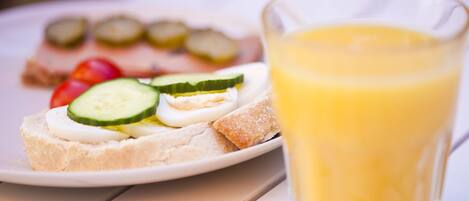 A plate with a sandwich and a glass of orange juice.