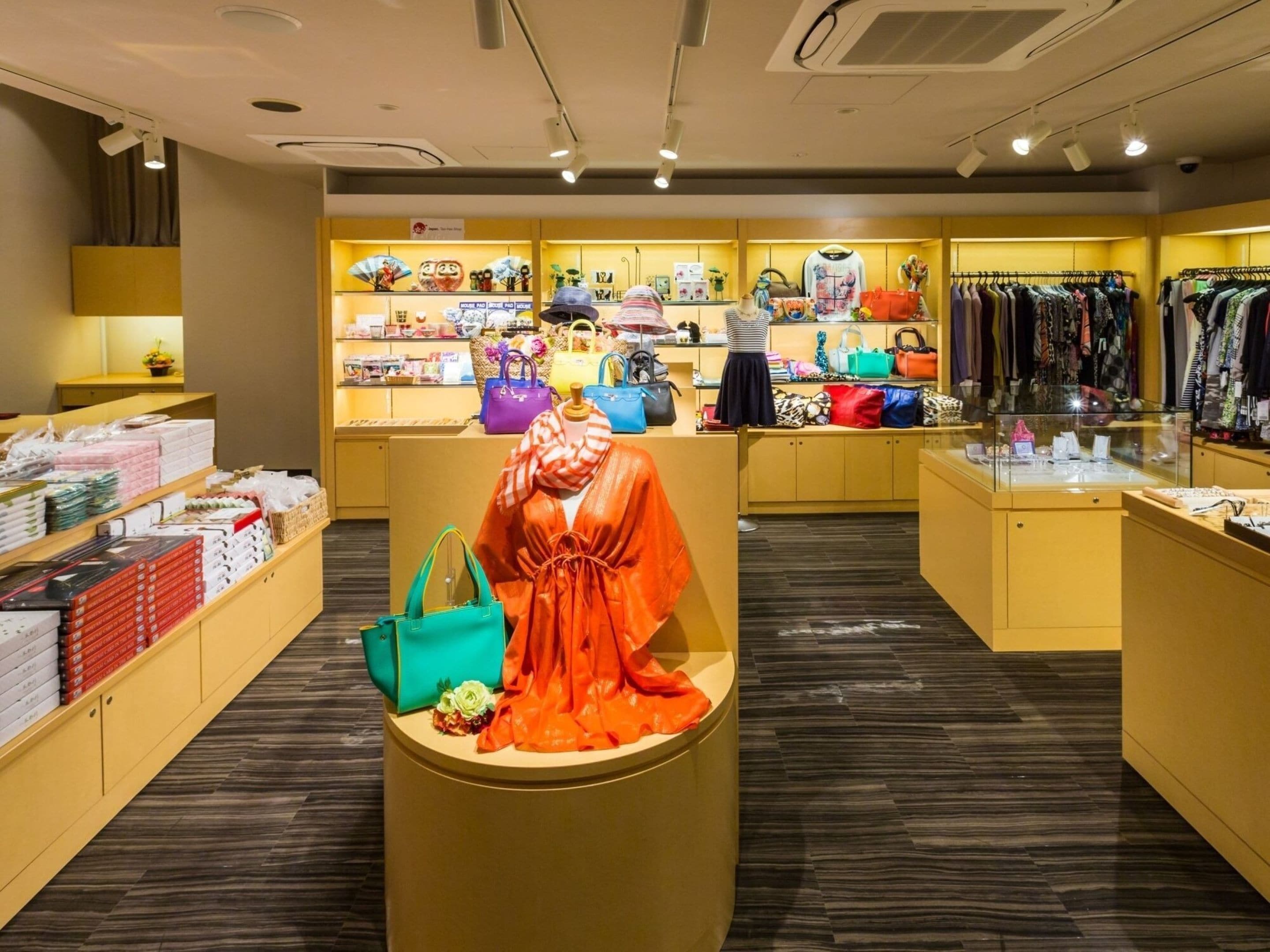 A boutique store with a display of handbags, clothing, and accessories.