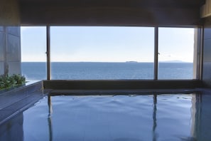 A large indoor swimming pool with a view of the sea through large windows. - Resorpia Atami (Atami)