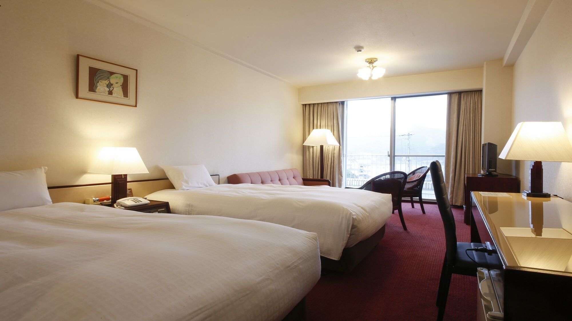 A hotel room with two beds, a desk, a chair, a TV, and a large window with curtains.
