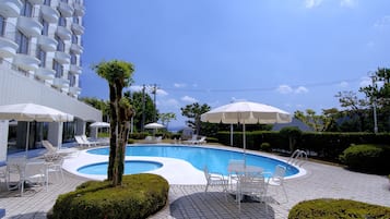 Een buitenzwembad, parasols voor strand/zwembad