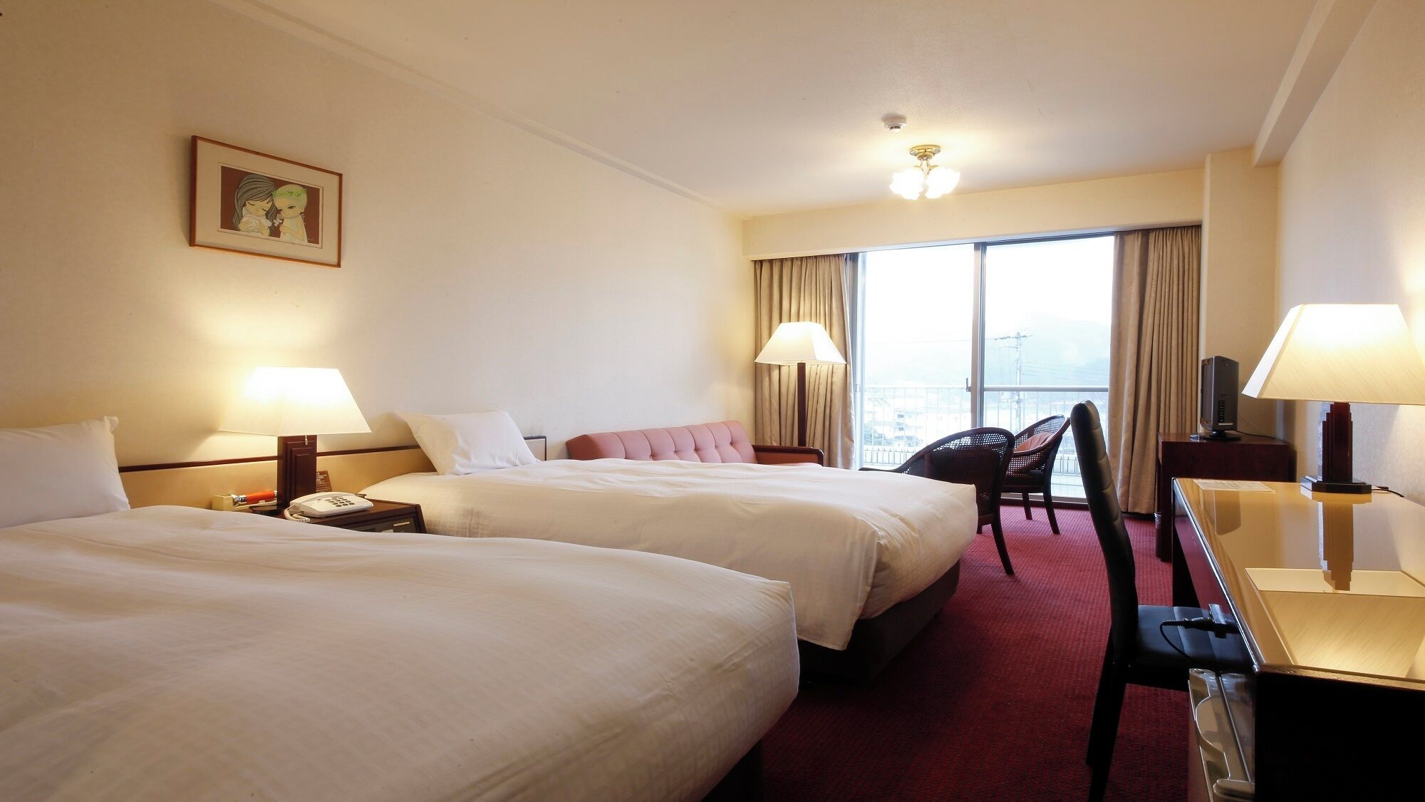 A hotel room with two beds, a desk, a chair, a lamp, a TV, and a large window with curtains.