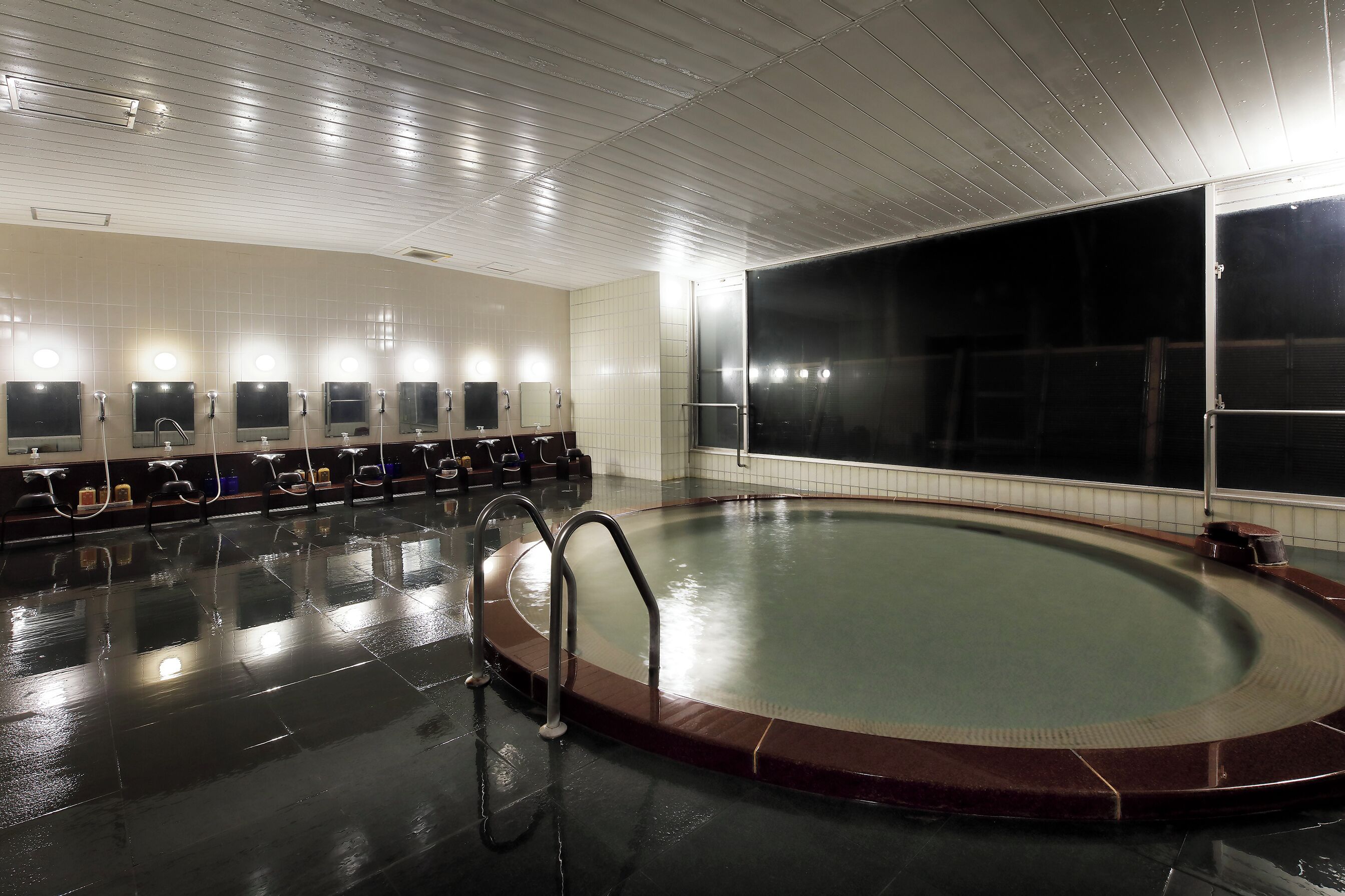 A swimming pool with a tiled floor and a glass wall.