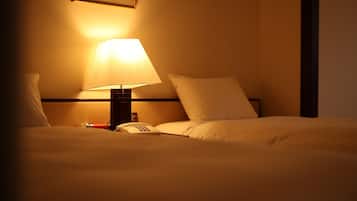 A hotel room with a bed, a bedside lamp, and a telephone.