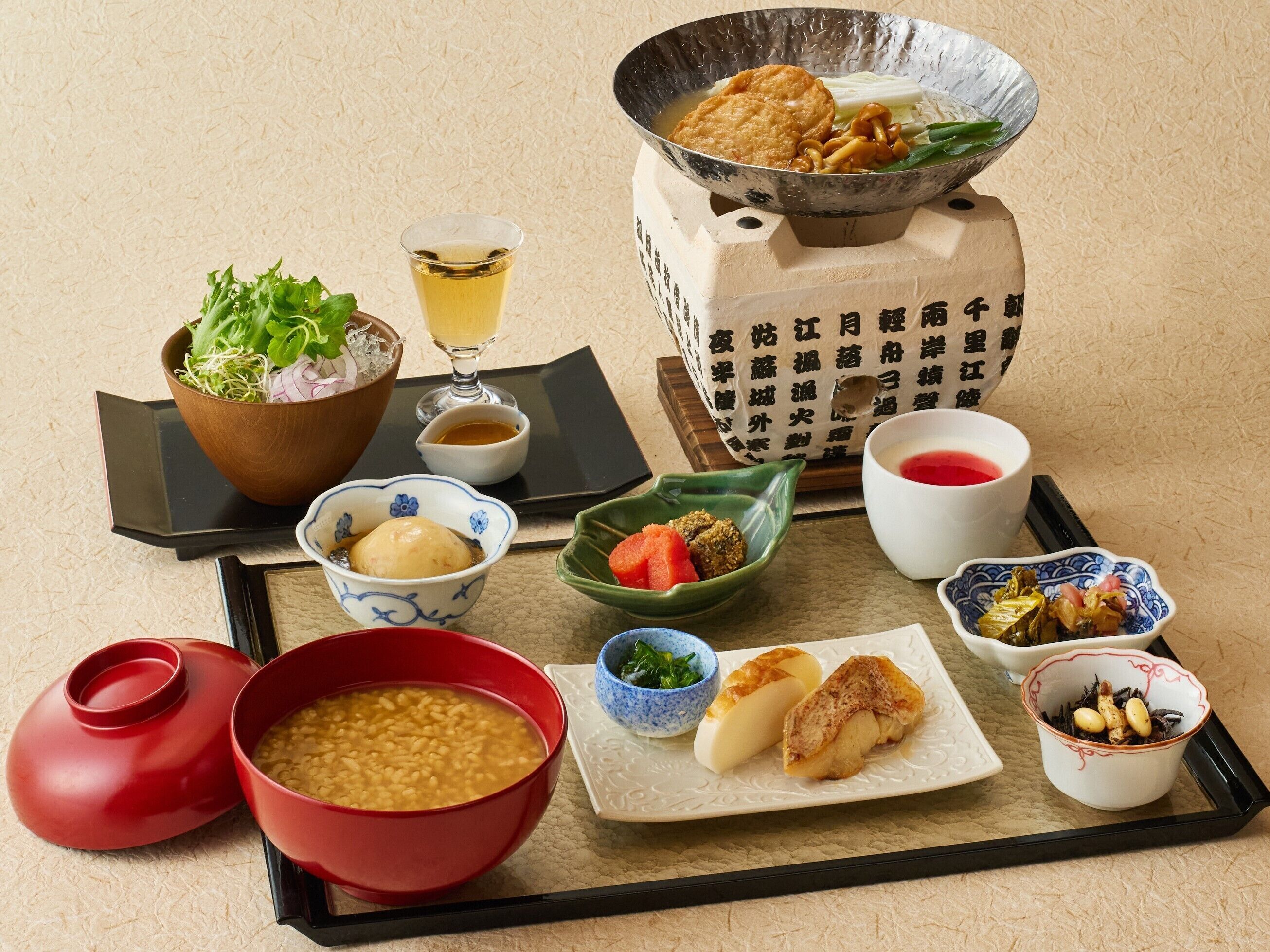 A variety of Japanese dishes including a bowl of soup, a plate with fish, and several small bowls with different foods.