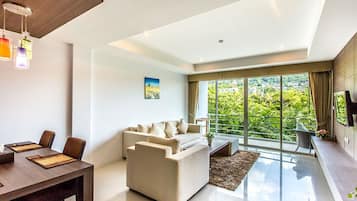 1 Bedroom Deluxe Suite | Área de sala de estar | Televisión LCD de 32 pulgadas con canales por cable y televisión