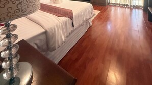 A bedroom with a bed, a TV, a desk, and a window with curtains. - Bangtao Tropical Residence Resort & Spa (Choeng Thale)