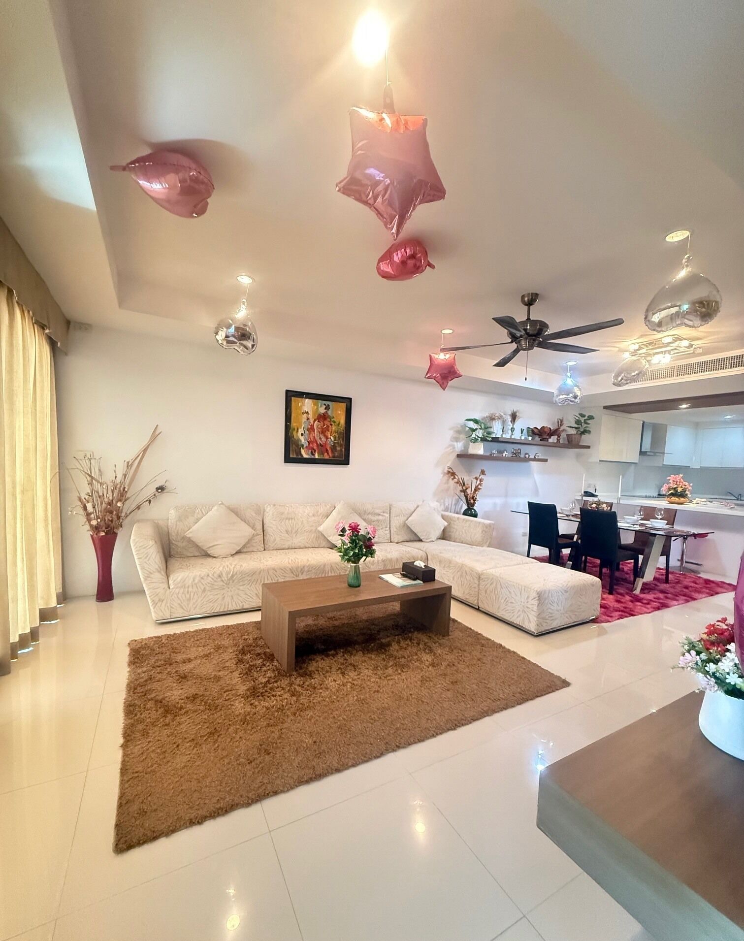 Una sala de estar moderna con un sofá modular, una mesa de centro y un comedor con un tapete rojo.
