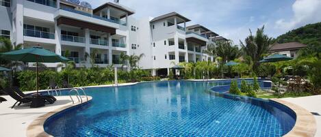 Una piscina al aire libre, sombrillas