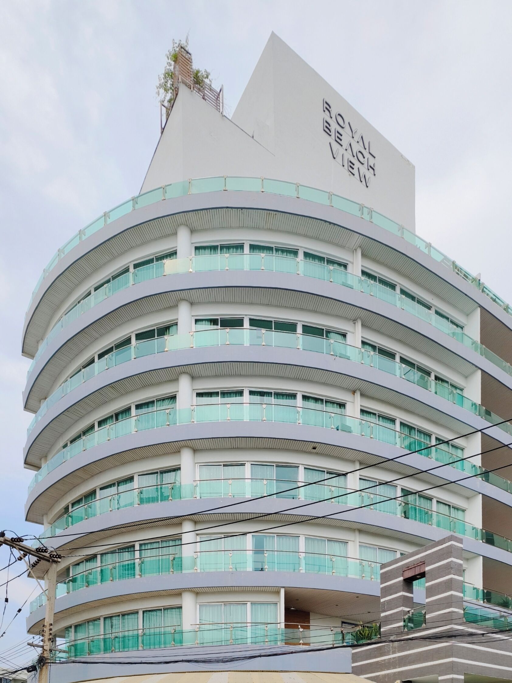 A multi-story hotel with a distinctive curved facade and balconies.