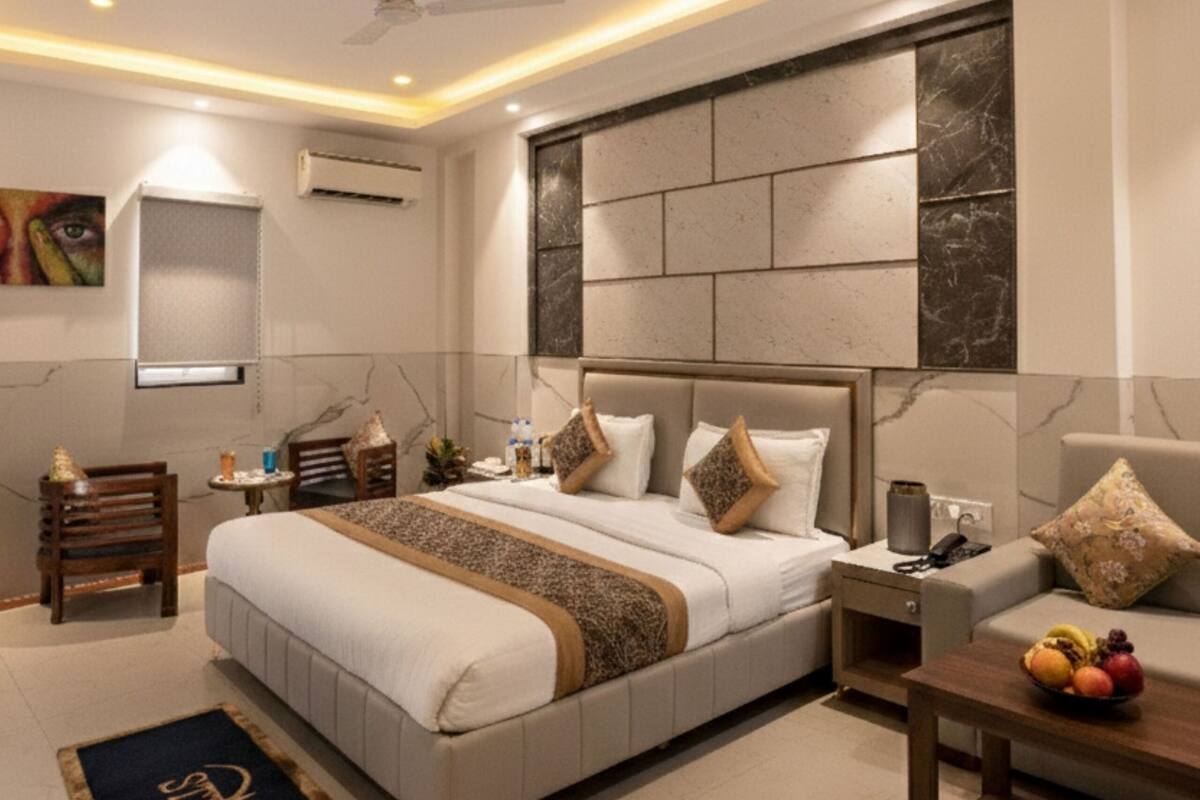 Un dormitorio moderno con una cama grande, mesitas de noche, un ventilador de techo y aire acondicionado instalado en la pared.