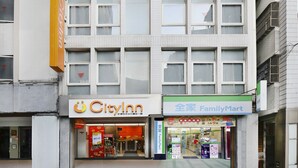 Een meerlaags gebouw met een City Inn en een FamilyMart op de begane grond.