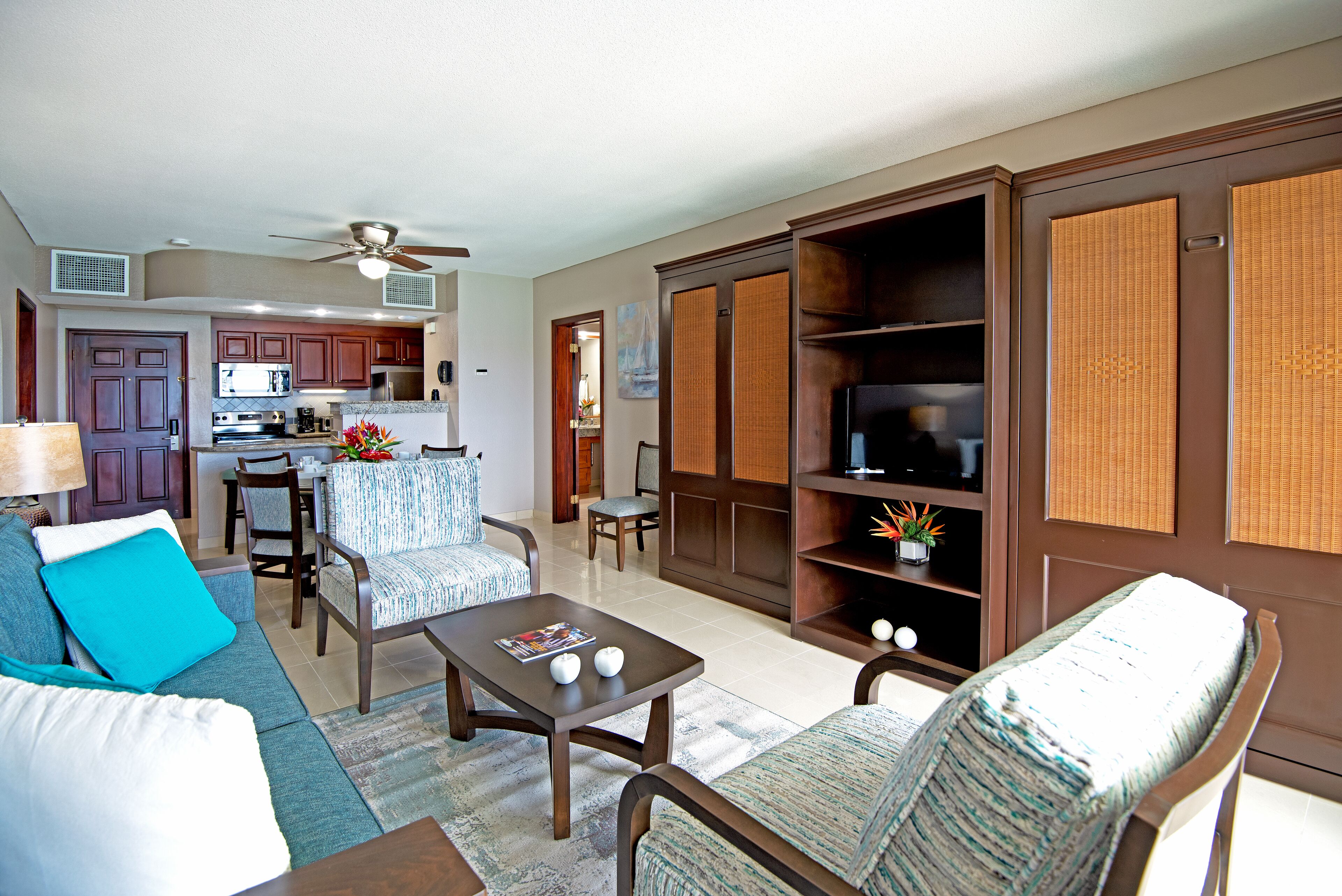 A living room with a sofa, chairs, a coffee table, and a TV stand.
