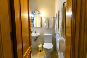 A bathroom with a toilet, sink, and towel rack.