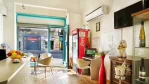 A modern hotel lobby with a reception desk, seating area, and a Coca-Cola refrigerator. - Loui Talpiot Hotel (Haifa)