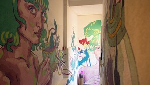 A hallway with colorful murals on the walls. - Loui Talpiot Hotel (Haifa)