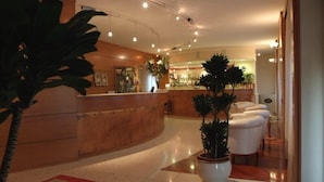 Un'hall dell'hotel con reception, zona salotto e bar.