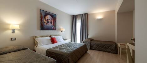 A hotel room with two beds, a desk, and a painting on the wall.