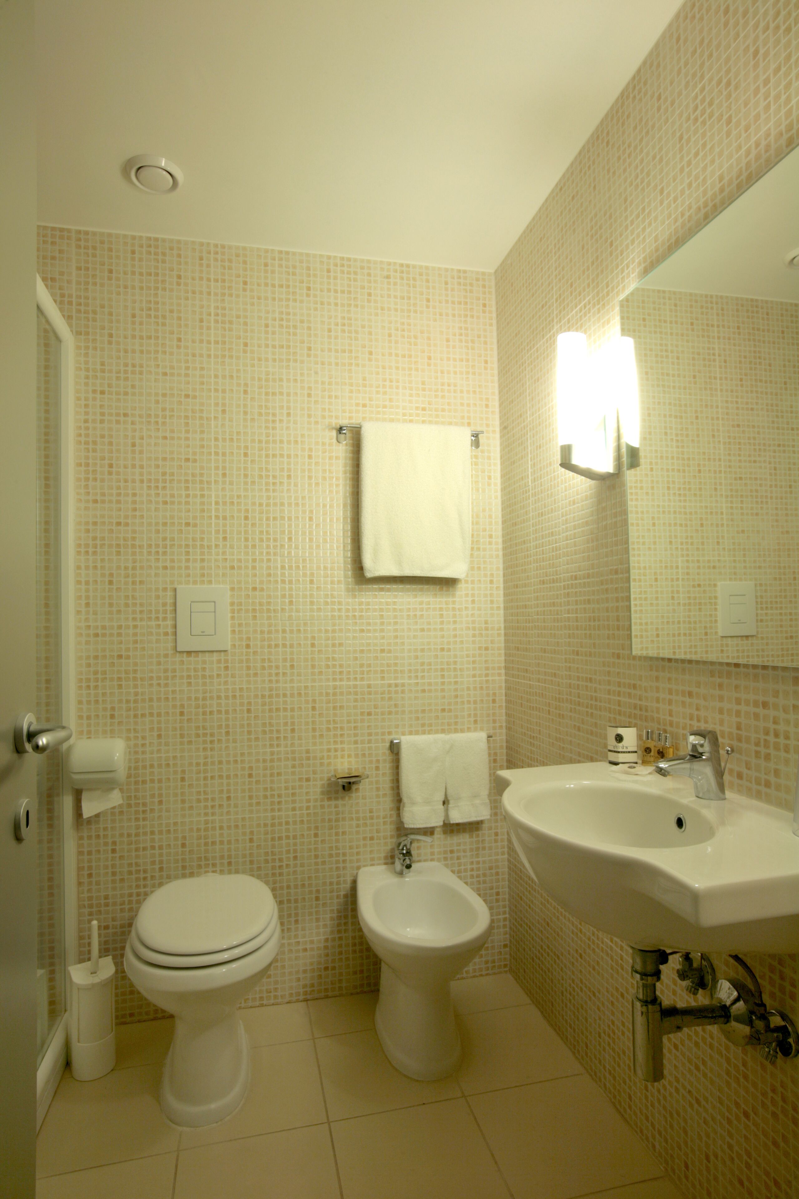 A bathroom with a toilet, bidet, and sink.