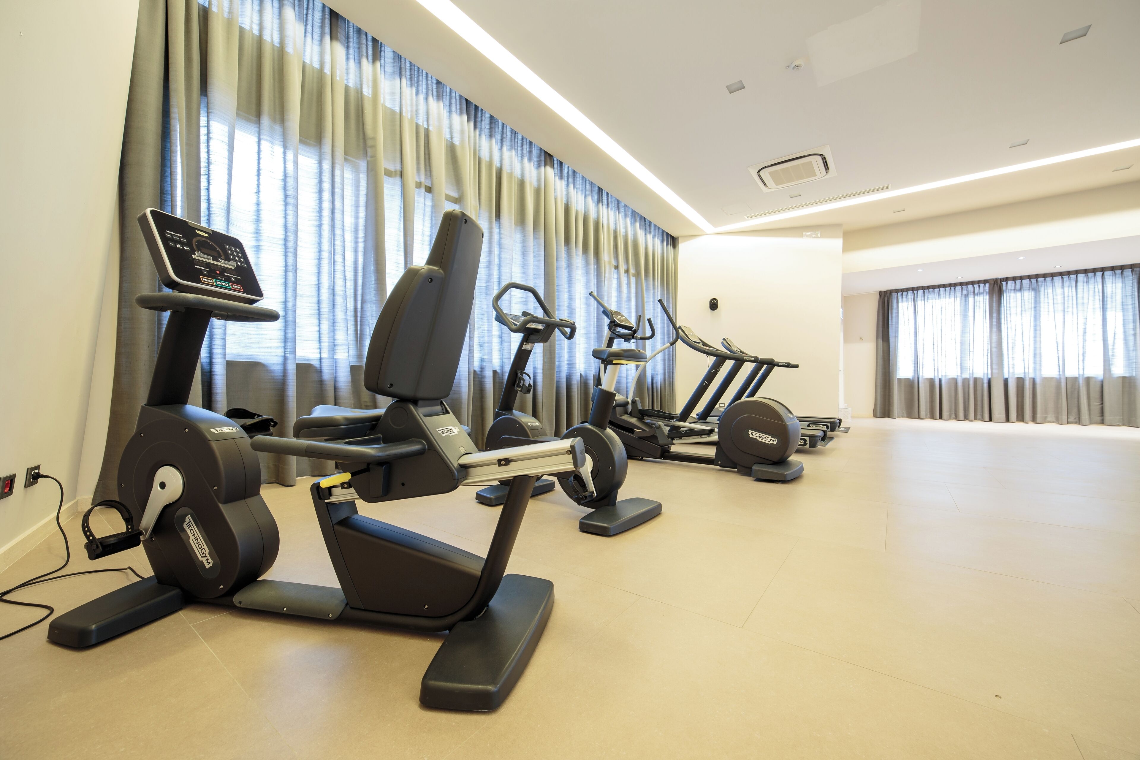 A gym with stationary bikes, treadmills, and elliptical machines.