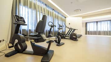 A gym with stationary bikes, treadmills, and elliptical machines.