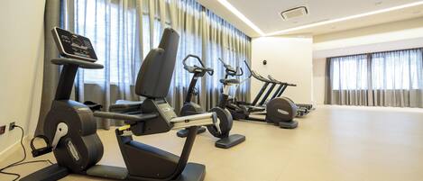 A gym with stationary bikes, treadmills, and elliptical machines.