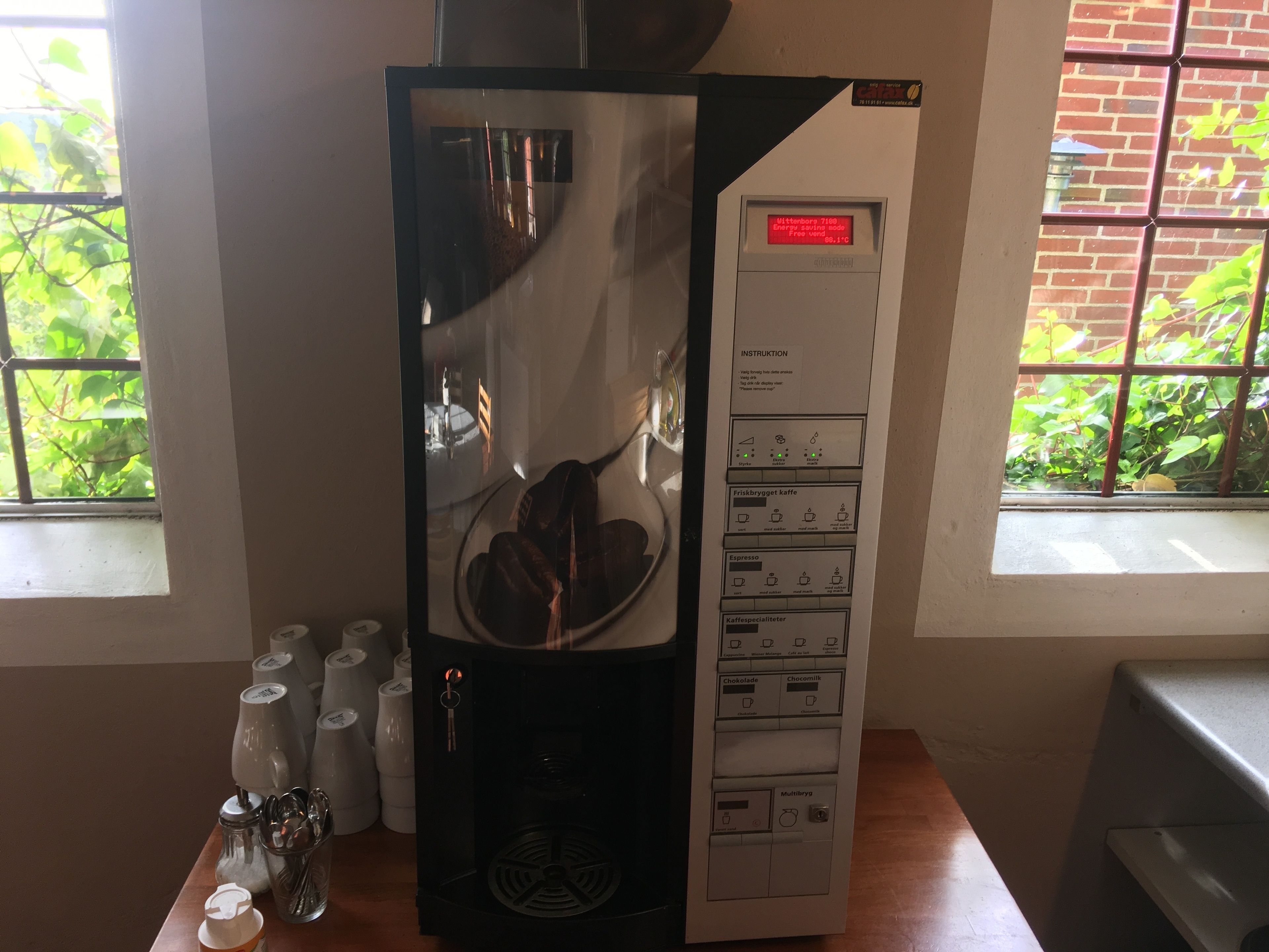 Une machine à café dotée d’un écran numérique, d’un panneau de commande et d’un système de capsules de café.