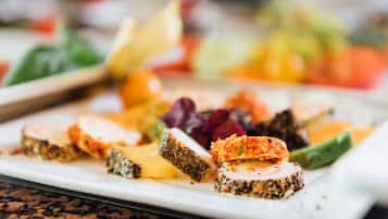 A plate of food with various items including slices of meat, cheese, and vegetables.