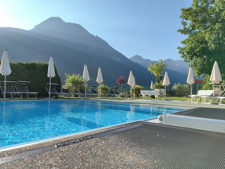 Una piscina techada, una piscina al aire libre, sombrillas. Hotel Angerwirt