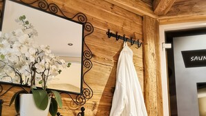 Un mur en bois avec un miroir, une robe blanche et une lampe jaune.