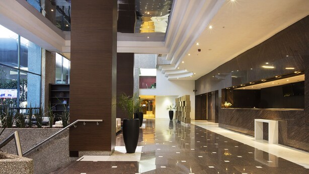 A modern lobby with a polished floor, a reception desk, and a staircase. - Krystal Urban Aeropuerto Cd de Mexico (Mexico City)