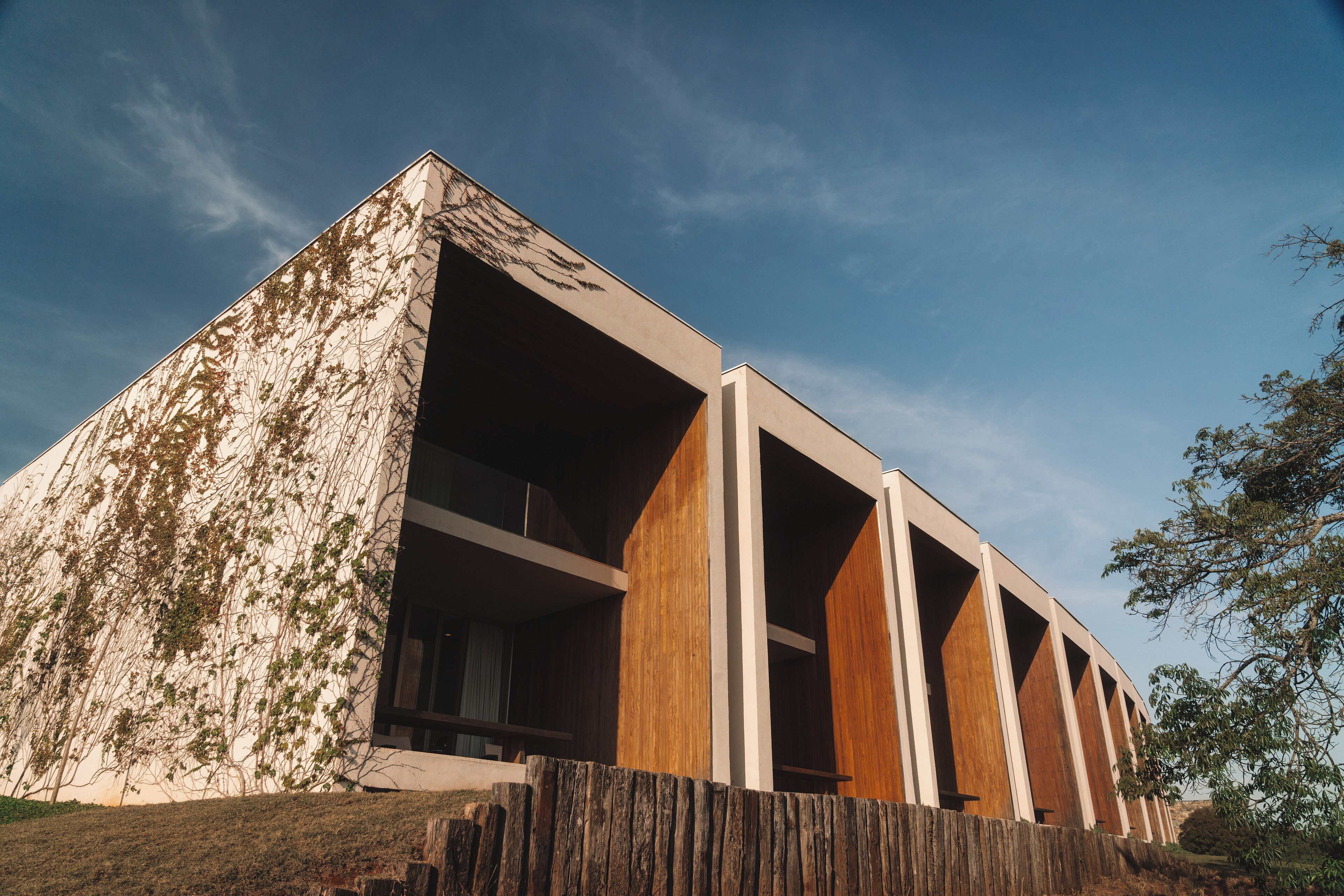 Un edificio moderno con techo inclinado y grandes columnas de madera.