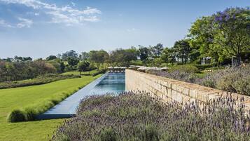 A landscaped garden with a water feature, stone walls, and lavender bushes.