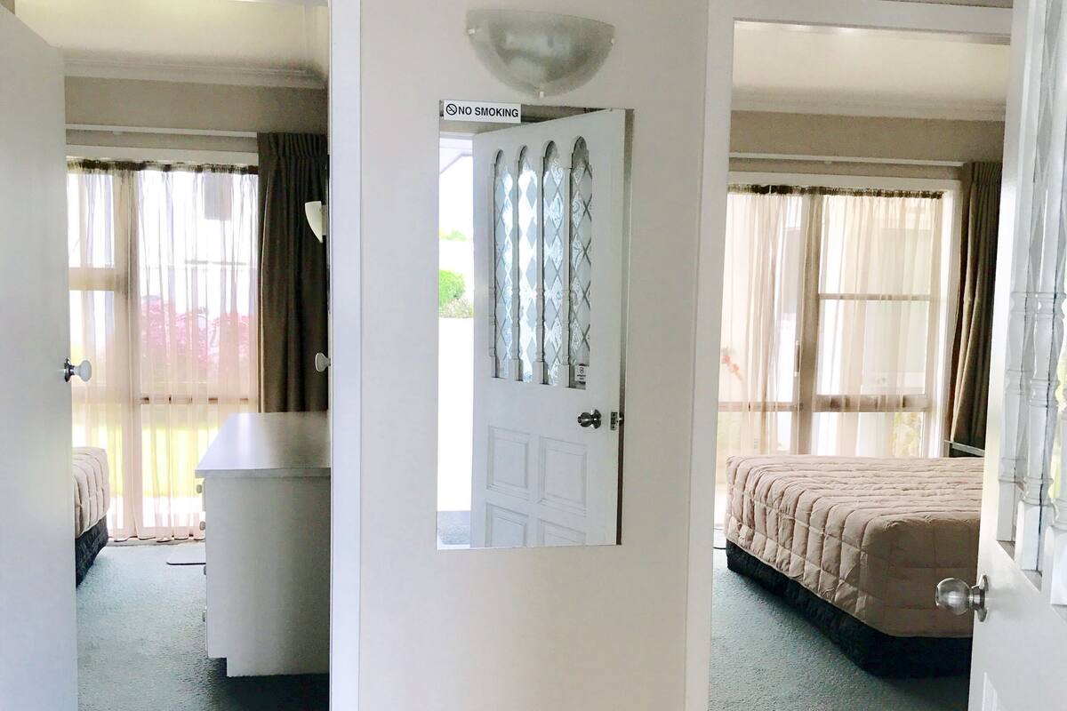 Una habitación de hotel con cama, baño y vistas al exterior.