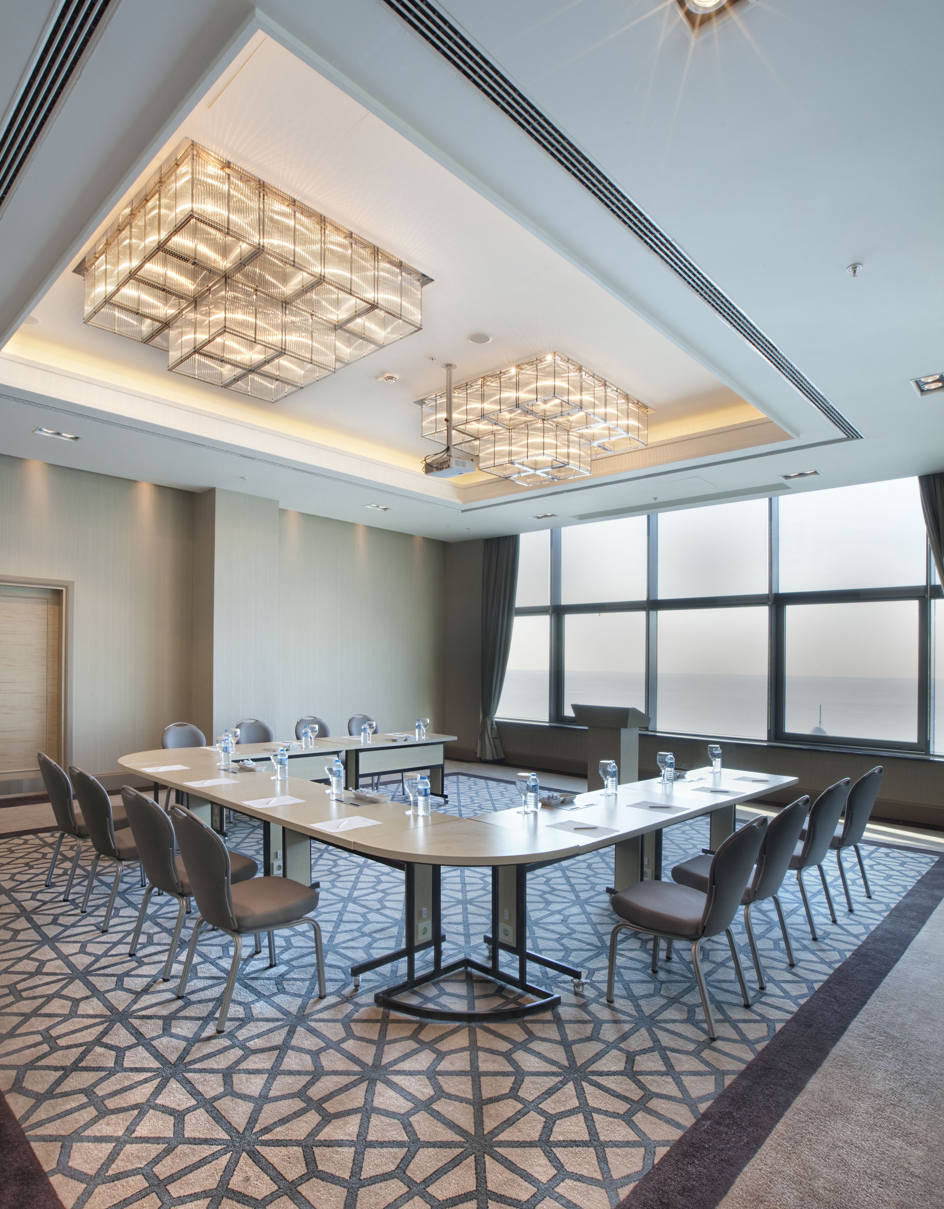 A conference room with a large table, chairs, and a modern chandelier.