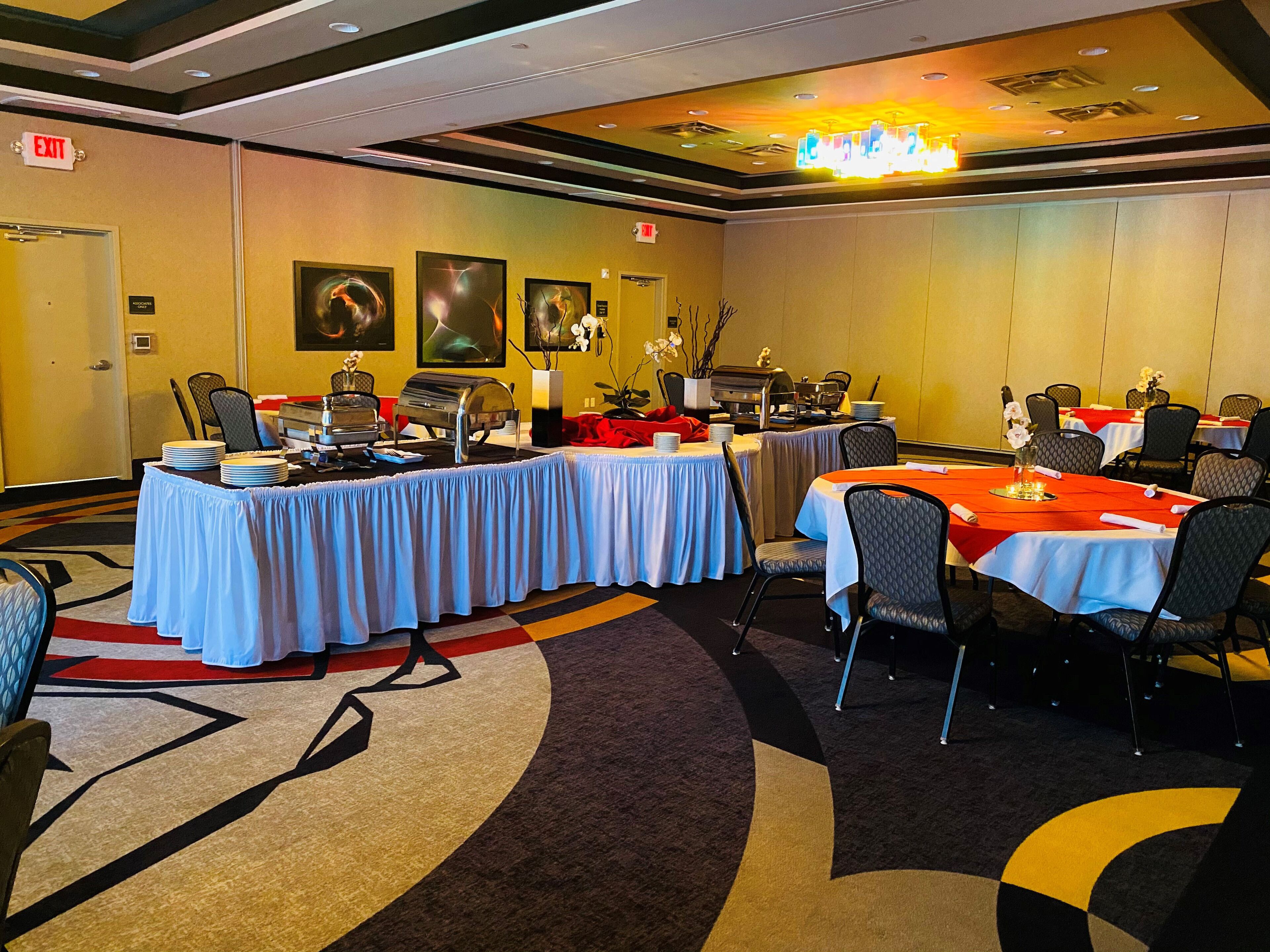 A conference room with tables set for a meeting, equipped with a grill and a buffet station.