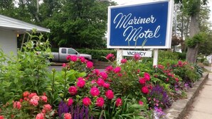A Mariner Motel sign with a vacancy notice, surrounded by vibrant flowers. - Mariner Motel (Falmouth)