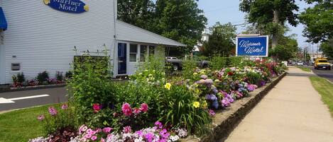 A motel with a sign reading "Mariner Motel" and a flower bed in front.