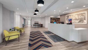 A modern reception area with a reception desk, seating area, and a large 'hello' sign on the wall.