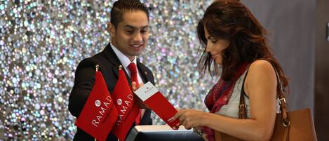 Un hombre y una mujer en la recepción, con un fondo brillante.