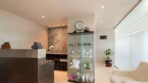 A reception area with a reception desk, a glass display case with toiletries, a clock on the wall, and a potted plant. - Ramada by Wyndham Abu Dhabi Downtown (Abu Dhabi)