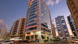 A multi-story hotel with a prominent 'Ramada' sign, featuring a modern architectural design with a mix of glass and concrete facades. - Ramada by Wyndham Abu Dhabi Downtown (Abu Dhabi)
