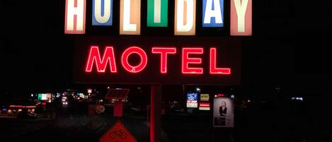 A neon sign for a Holiday Motel with a vacancy sign below it.