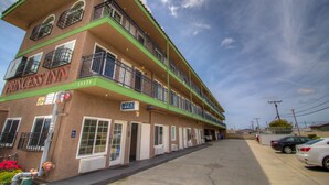 A multi-story motel with balconies, a sign reading "Princess Inn," and a parking lot with cars.