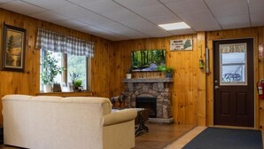 A cozy room with a stone fireplace, a sofa, and a sign above the door.