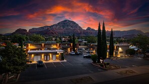 A hotel with a parking lot, a mountain in the background, and a sunset sky. - Dreamcatcher Inn of Sedona (Sedona)