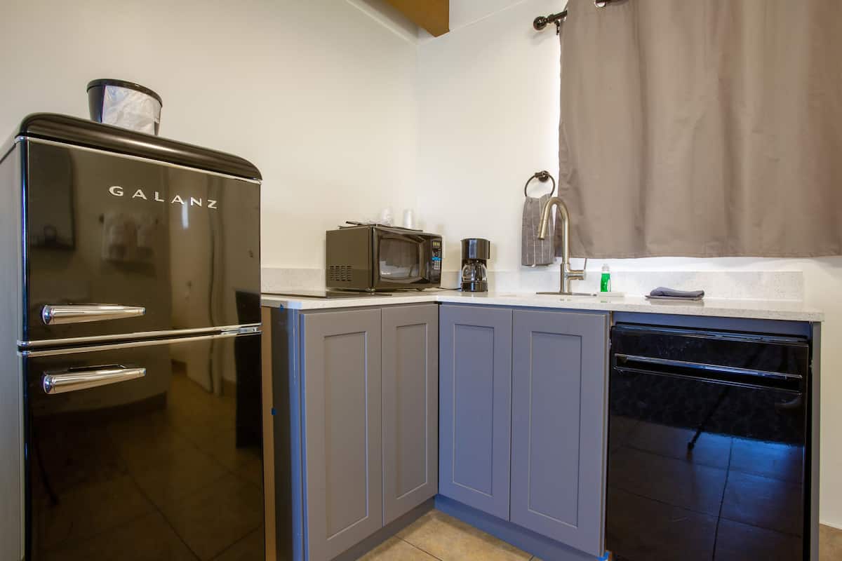 A compact kitchen with a Galanz refrigerator, a microwave, and a coffee maker.