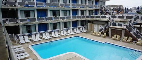 Ein Hotel mit Poolbereich, mehreren Balkonen und einer Treppe zu den oberen Etagen.