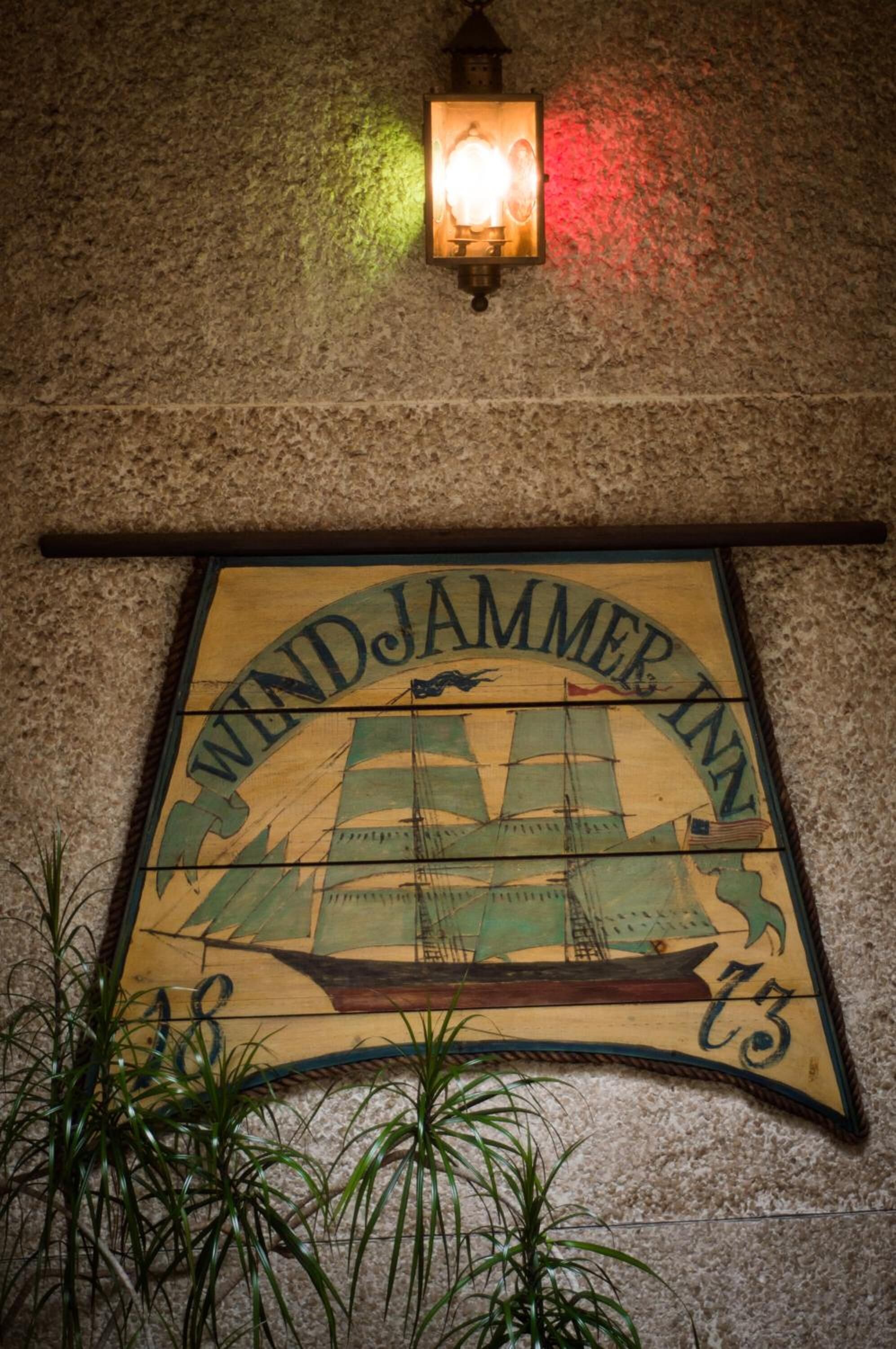 Et ophængt skilt for Windjammer Inn med et maritimt tema, der inkluderer et skib og et anker.